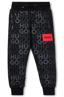 Kids' fleece tracksuit bottoms with all-over logo print