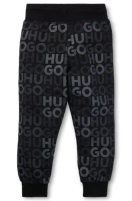 Kids' fleece tracksuit bottoms with all-over logo print